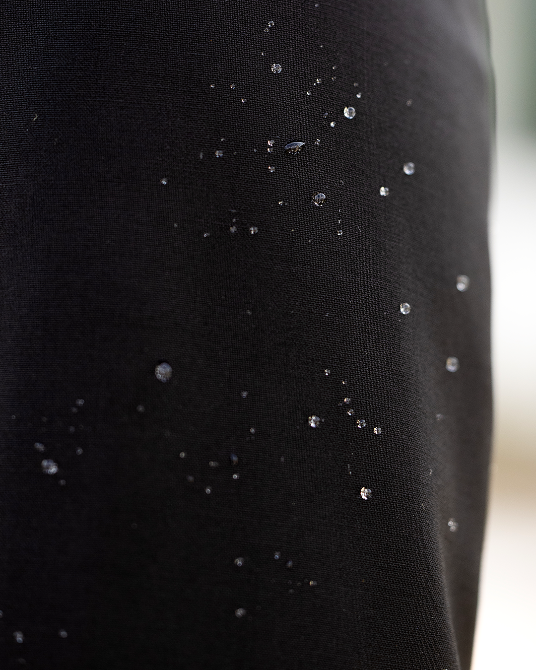 Detail of black JuulC women's frack, made of sport-tech merino wool with water-repellent properties