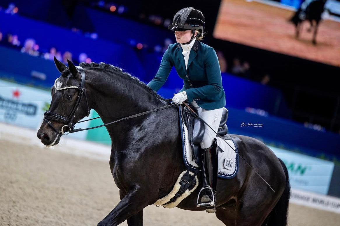 Mercedes Verweij rewarding her horse after their dressage test at an international show, in a JuulC competition jacket