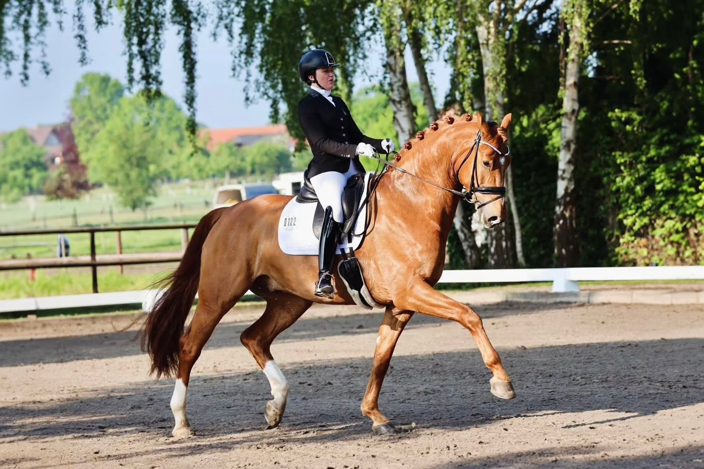 Jennifer Stein riding an extended trot with her chestnut during their dressage test, in a JuulC competition coat 