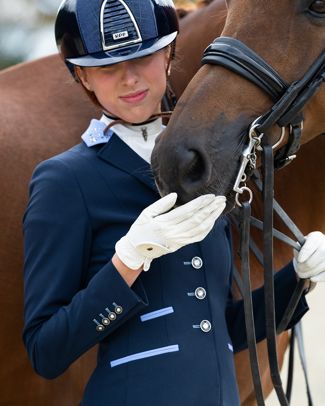 Model with horse wearing JuulC' Navy Light Blue Women's Show Coat made from sport-tech merino wool 